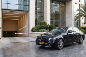 רכב שחור ליד מחסום בכניסה לחניון תת קרקעי של בניין משרדים